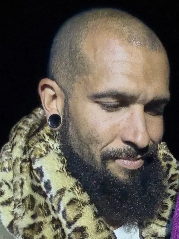 An ordinary snapshot of a bearded man in a leopard-print coat
